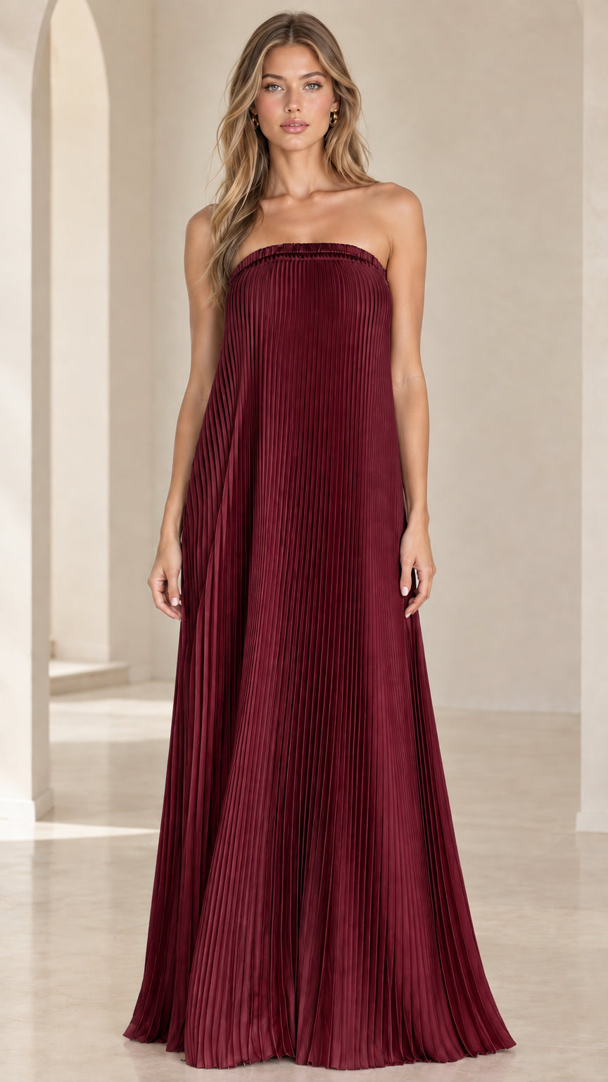 Front view of model wearing a burgundy wine red strapless pleated maxi dress