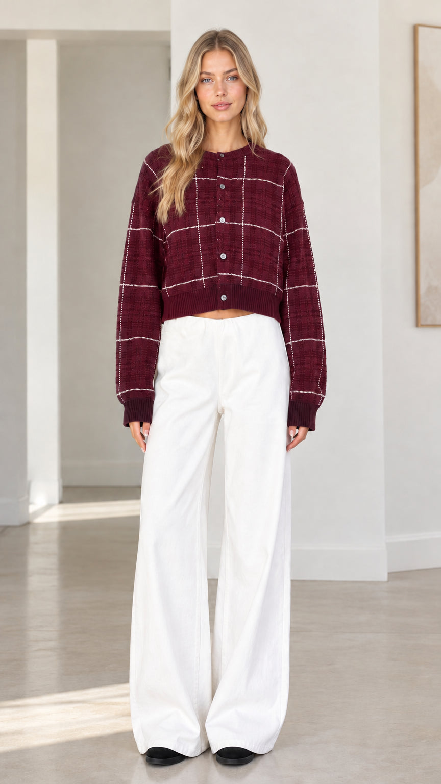 Front view of woman wearing burgundy wine plaid cropped cardigan sweater with white wide-leg trousers