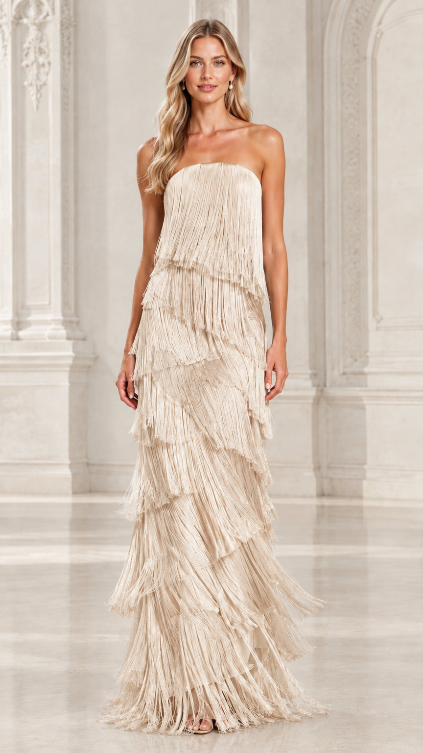 Front view of model wearing champagne beige strapless tiered fringe maxi evening gown