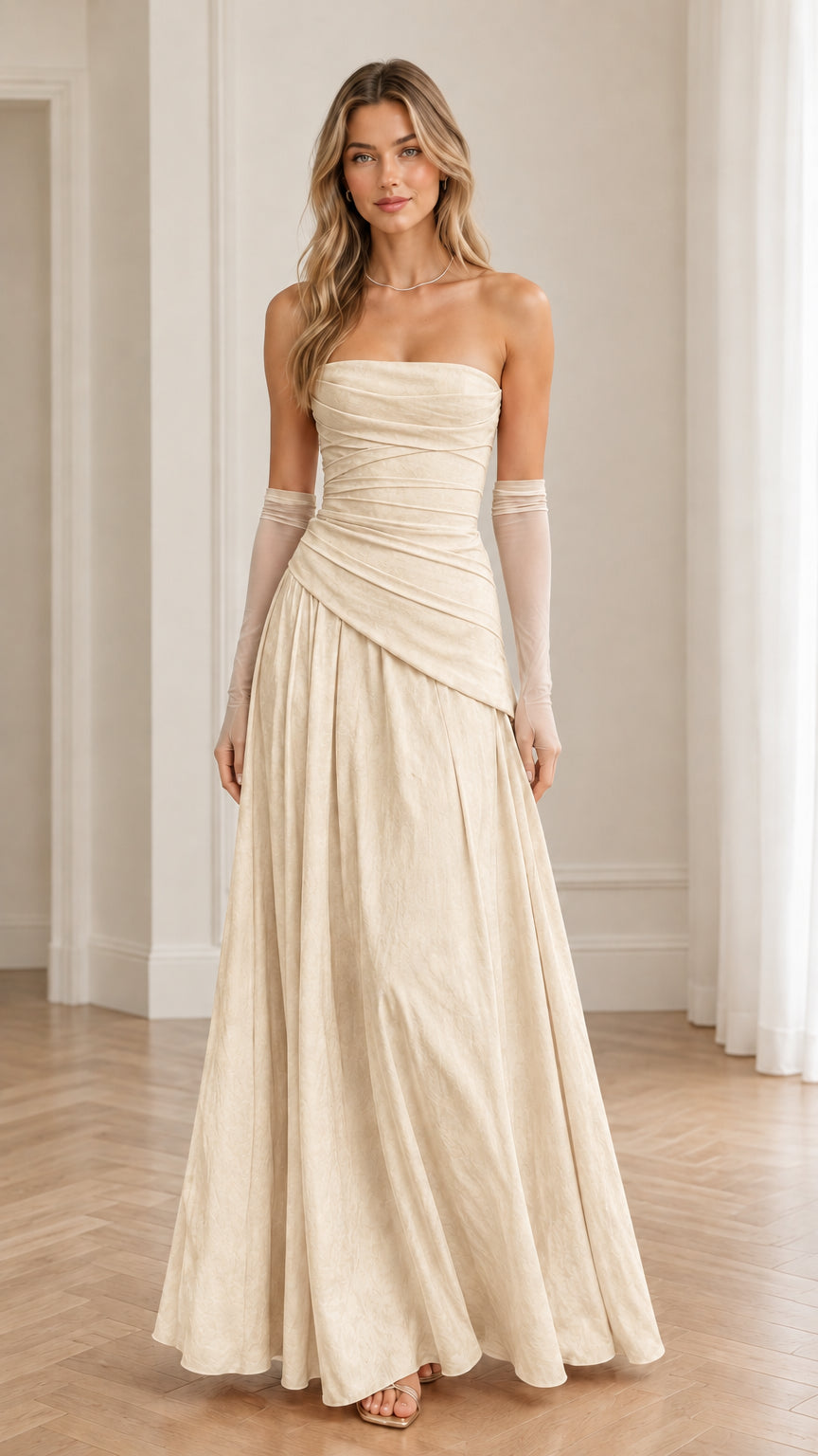 Model wearing champagne cream strapless ruched maxi gown with matching sheer gloves