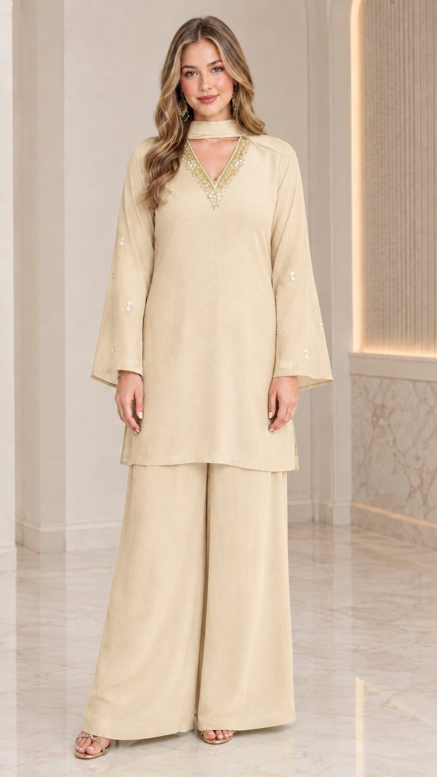 Front full-length view of model wearing champagne beige embellished tunic and wide-leg pant set
