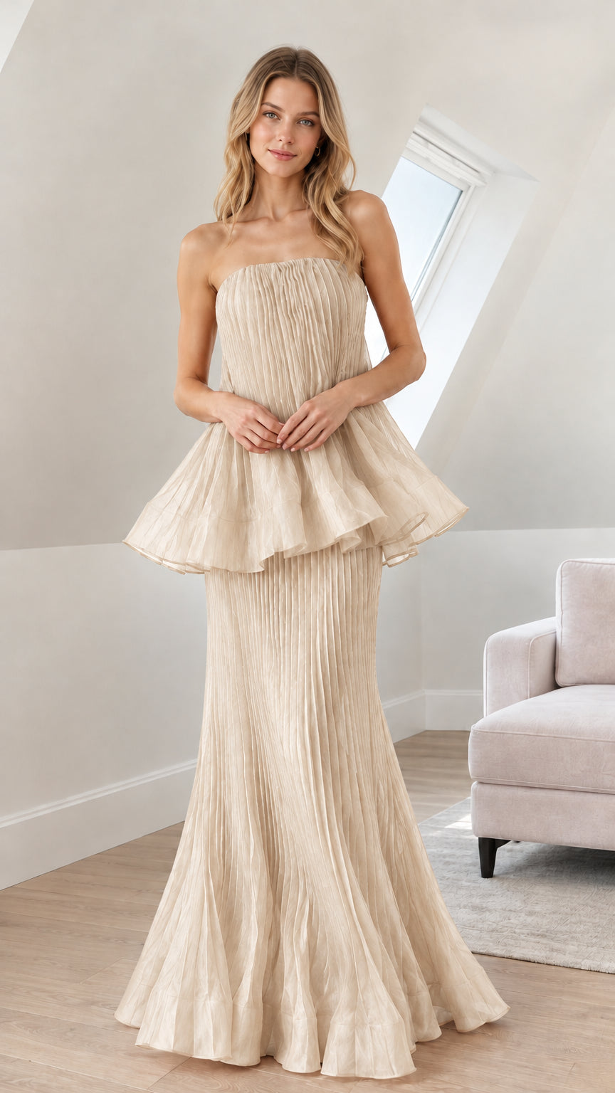 Front view of woman wearing champagne beige strapless pleated peplum gown