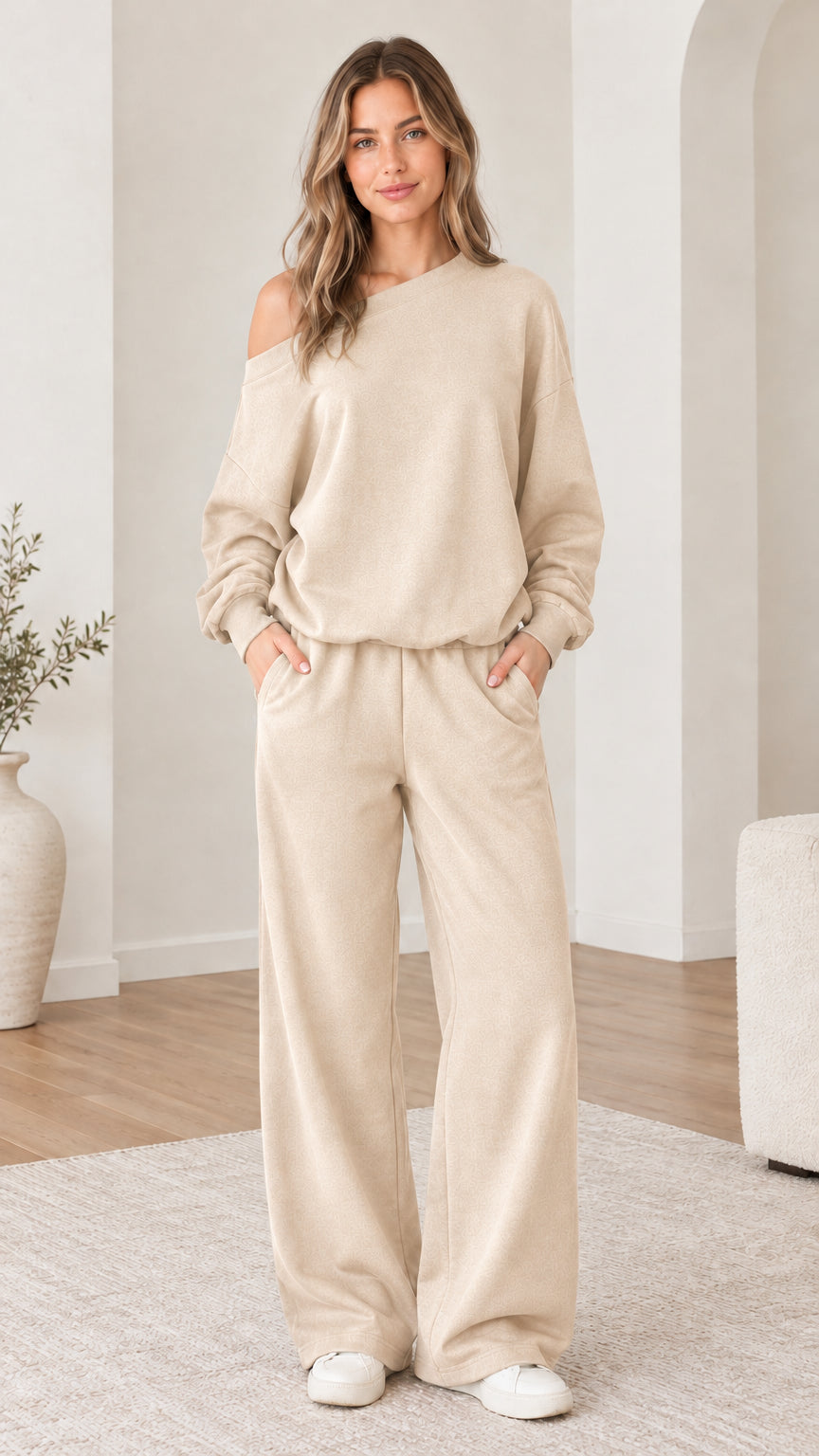 Model wearing beige cream one-shoulder sweatshirt and wide-leg sweatpants set