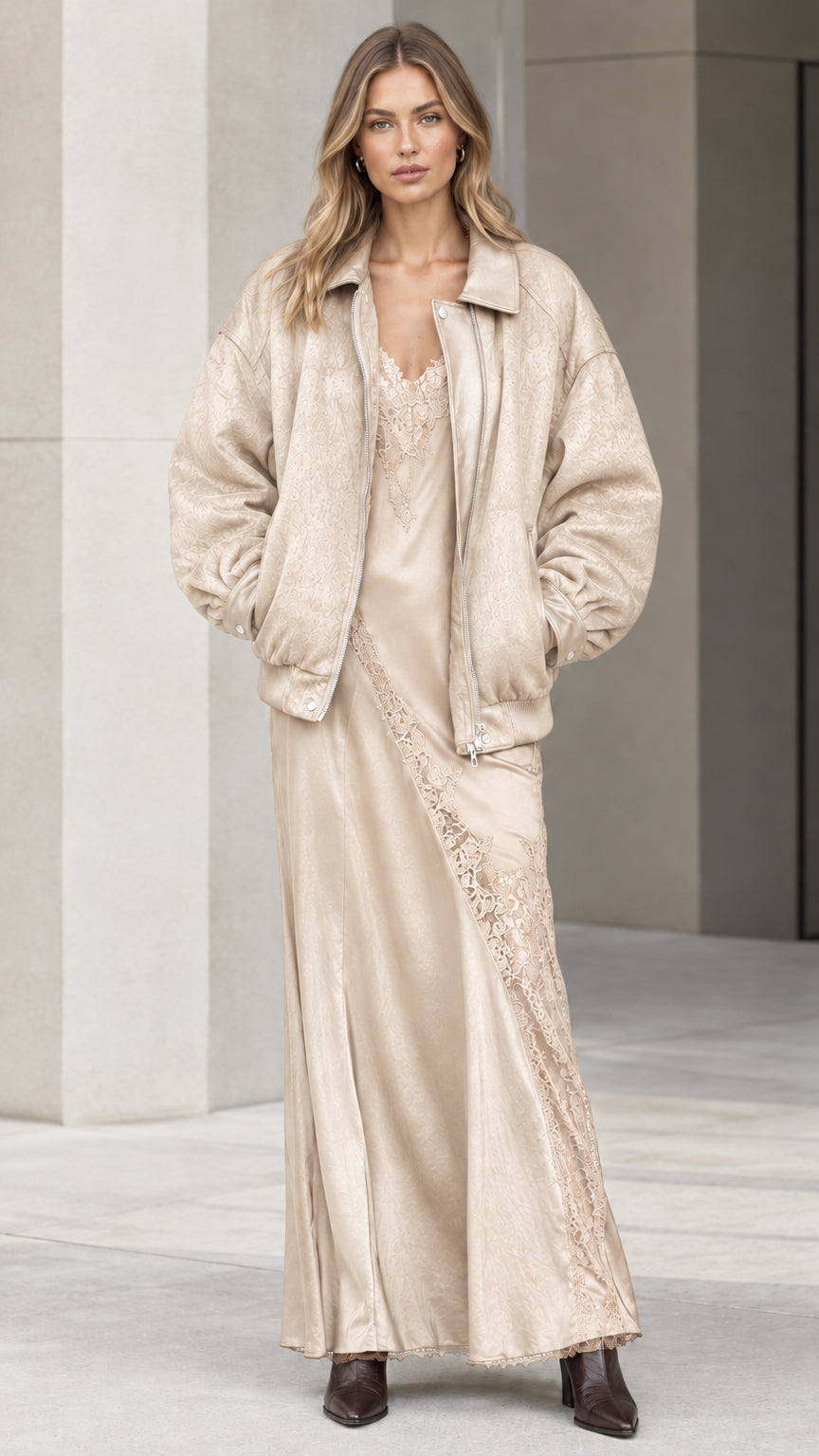 Model wearing champagne cream bomber jacket and coordinating slip dress set