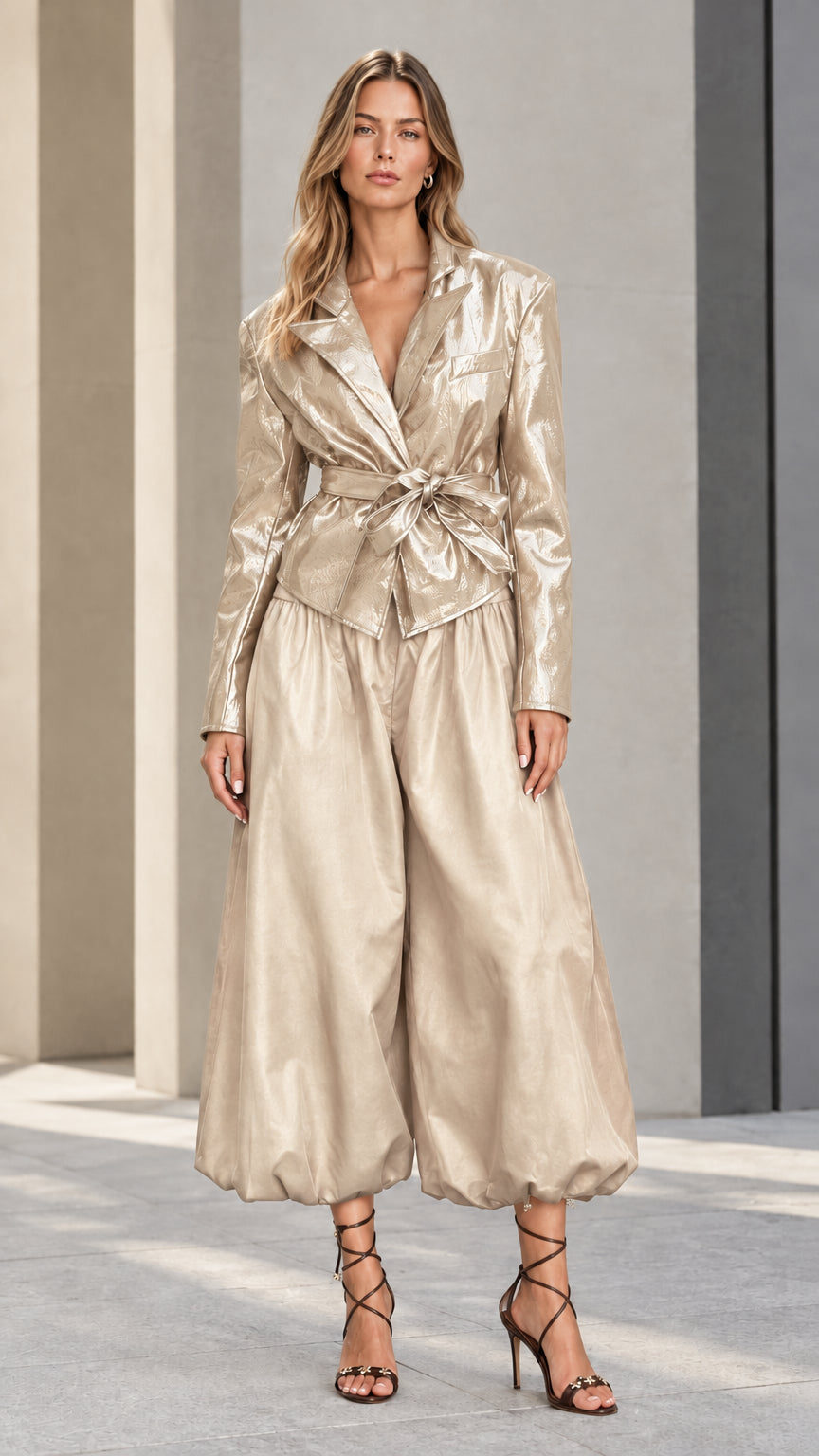 Front view of model wearing champagne metallic glossy belted blazer and balloon pants set