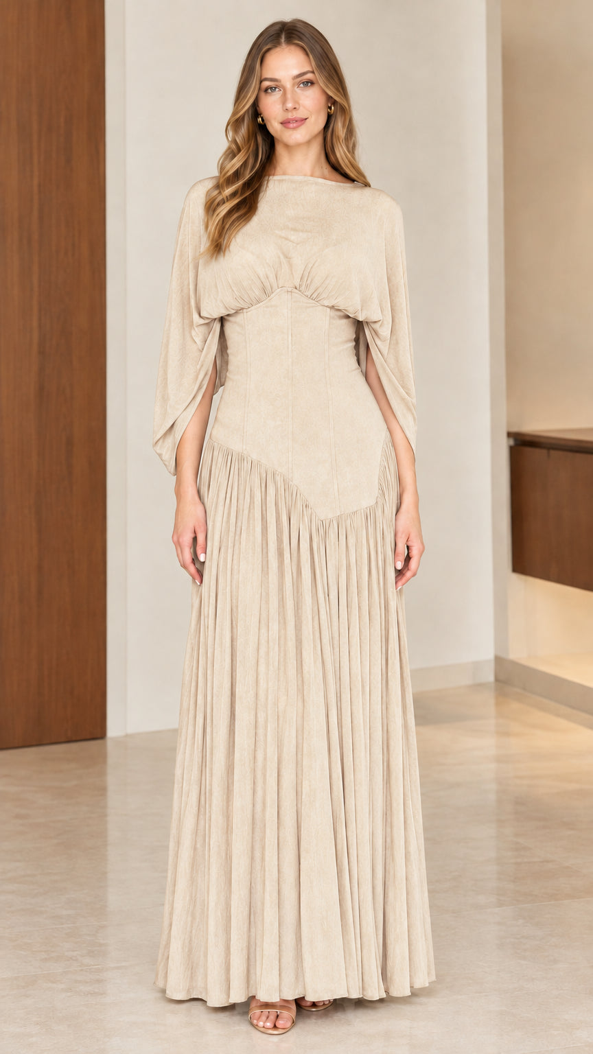 Full-length front view of model wearing champagne beige pleated maxi evening dress