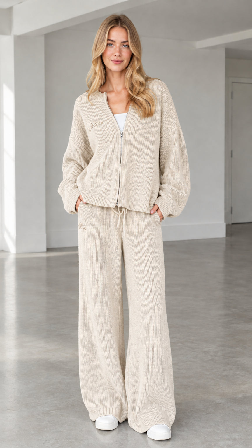 Front full view of woman wearing beige cream ribbed knit zip-up cardigan and wide-leg pants set