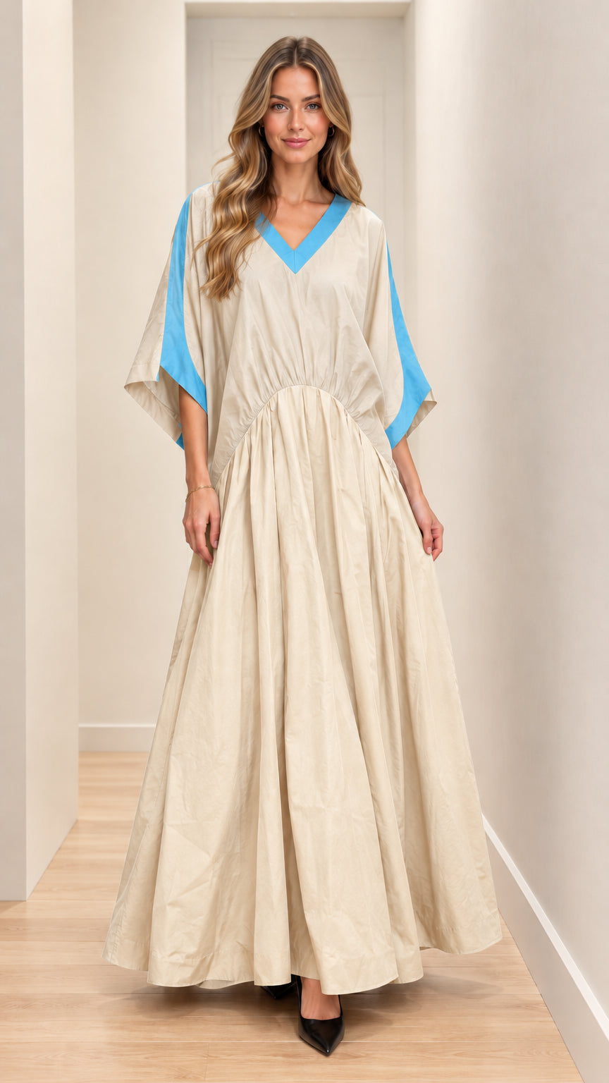 Front full-length view of model wearing beige maxi dress with blue contrast trim