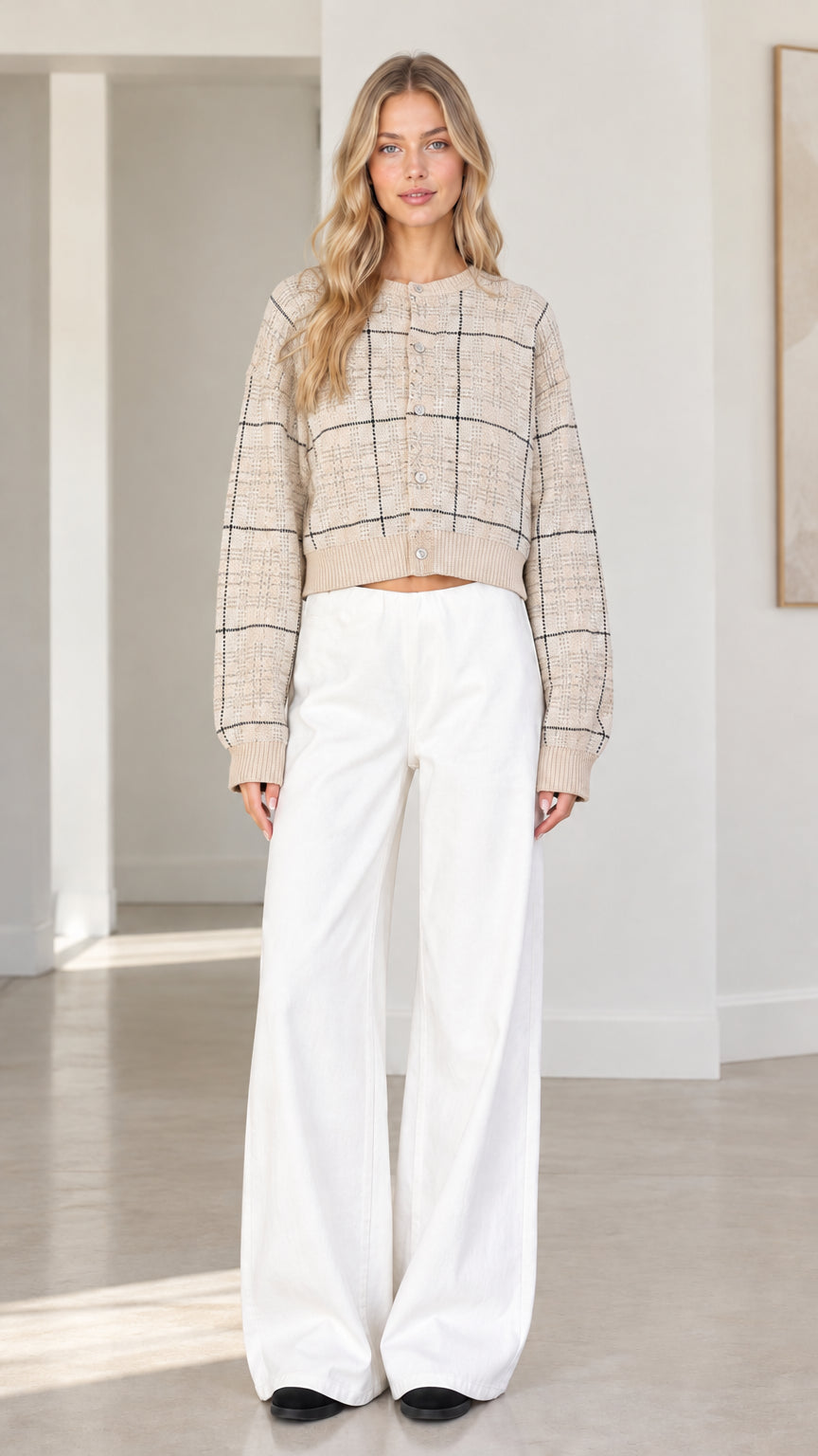 Front view of woman wearing beige oatmeal plaid cropped cardigan sweater with white wide-leg trousers